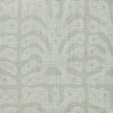 Detail of fabric in an abstract leaf print in light green and gray.