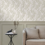 A maximalist living room with a wall papered in a painterly leaf print in cream on a white field.
