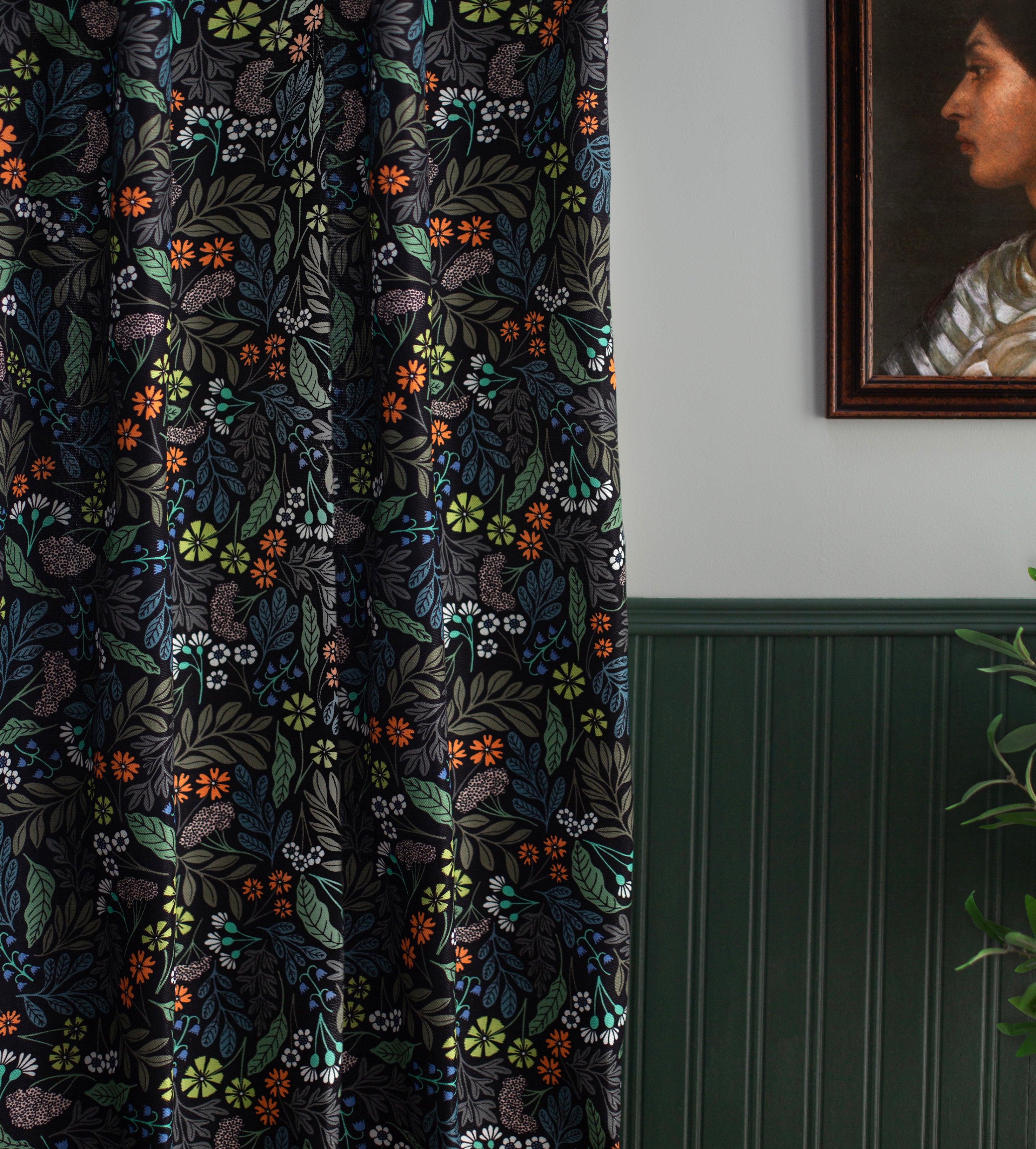 A wood-paneled wall and a curtain in a small-scale floral print on a black field.