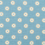 Detail of fabric in a playful dot print in cream and charcoal on a light blue field.