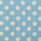 Detail of fabric in a playful dot print in cream and charcoal on a light blue field.