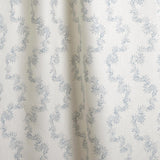 Draped fabric with stripe pattern of stylized  blue leaves on a beige background