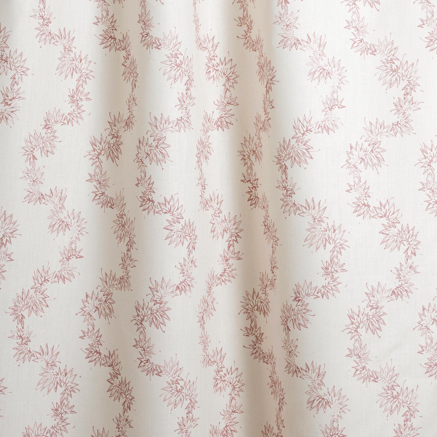 Draped fabric with stripe pattern of stylized pink leaves on a beige background
