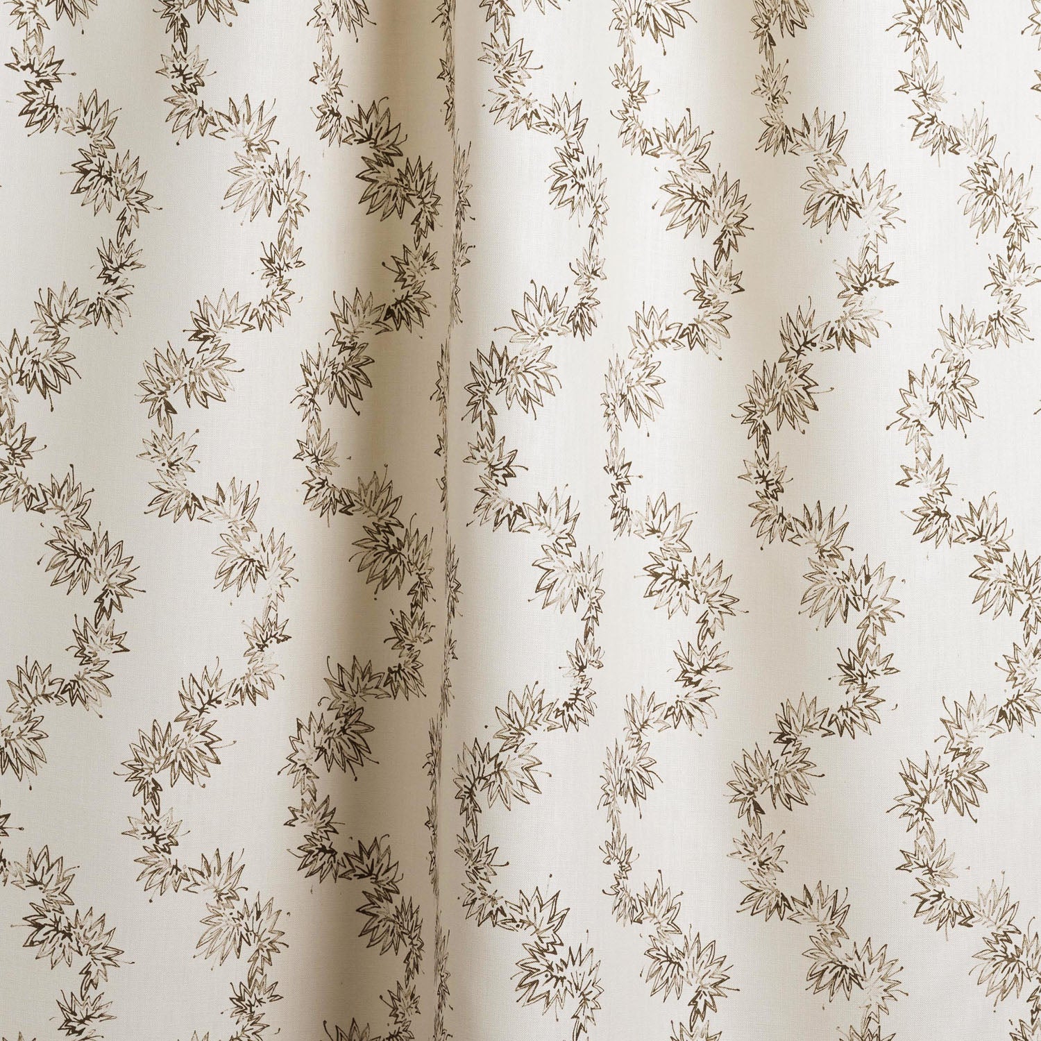 Draped fabric with stripe pattern of stylized dark brown leaves on a beige background