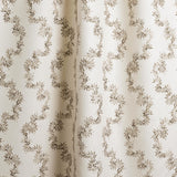 Draped fabric with stripe pattern of stylized dark brown leaves on a beige background