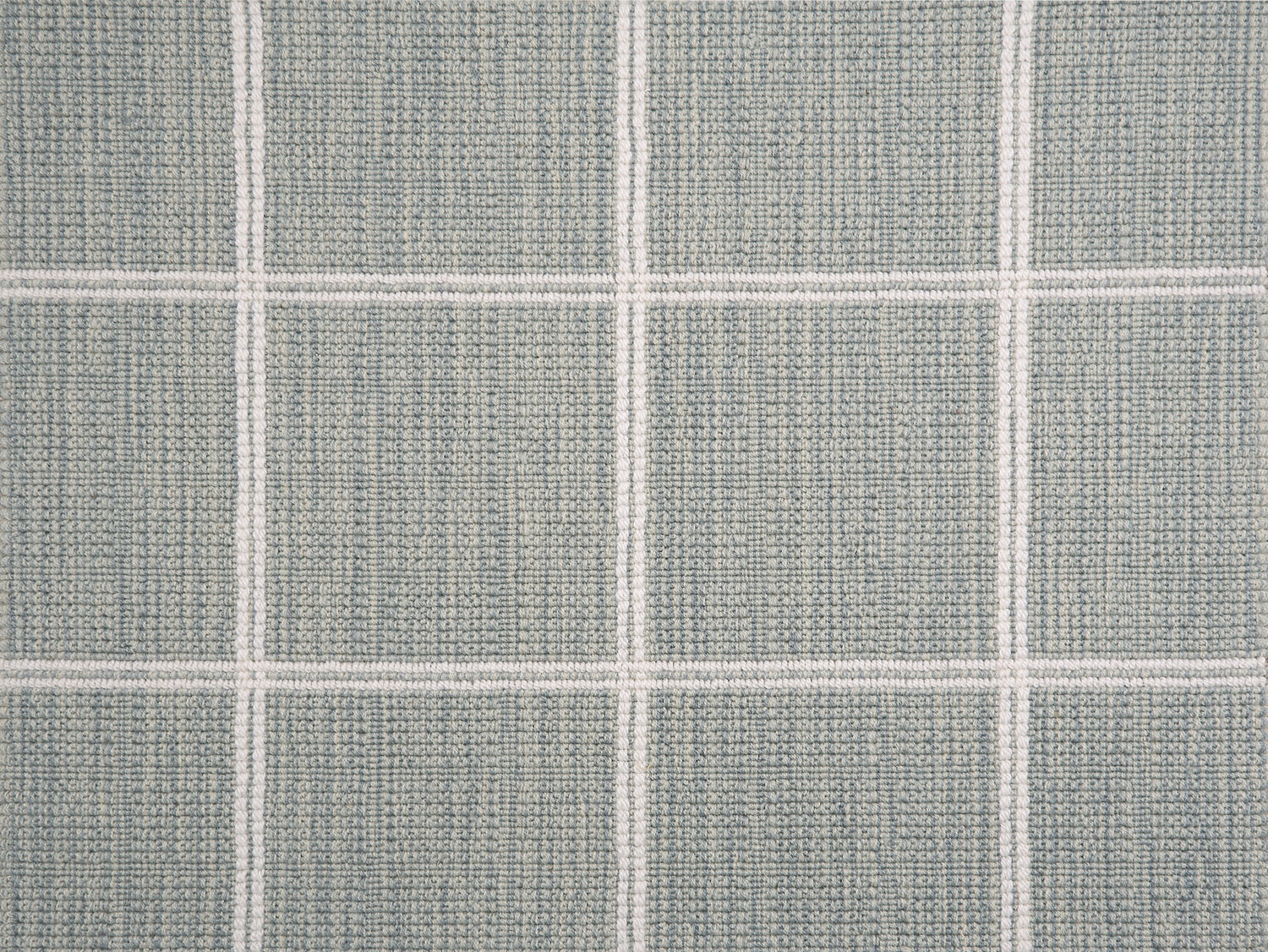 Broadloom carpet sample with windowpane grid in cream on a sky blue background. 