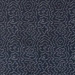 Detail of fabric in a minimalist wood grain print in white on an indigo field.