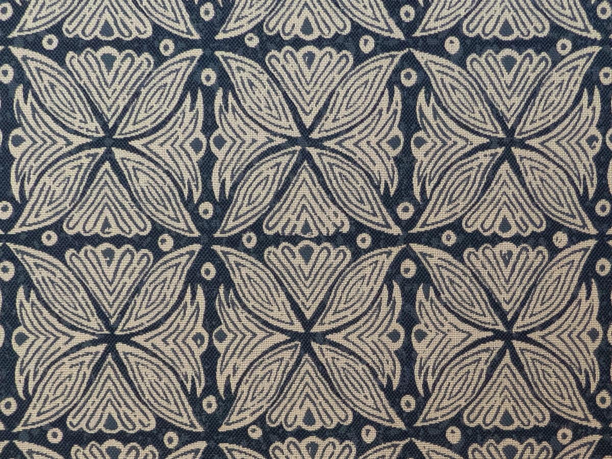 Detail of fabric in a botanical geometric print in shades of brown and navy.
