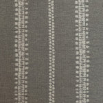 Detail of fabric in an irregular stripe print in gray on a slate field.