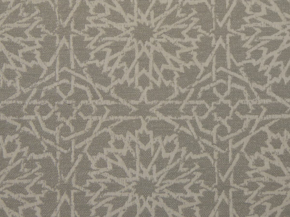 Detail of fabric in a small-scale lattice print in light gray on a gray field.