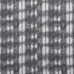 Detail of fabric in a textural shibori print in shades of charcoal on a greige field.