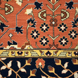Close-up of a patterned rug with intricate designs on a red and black background.