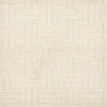 A close-up of a handwoven carpet with a repeating geometric maze in cream