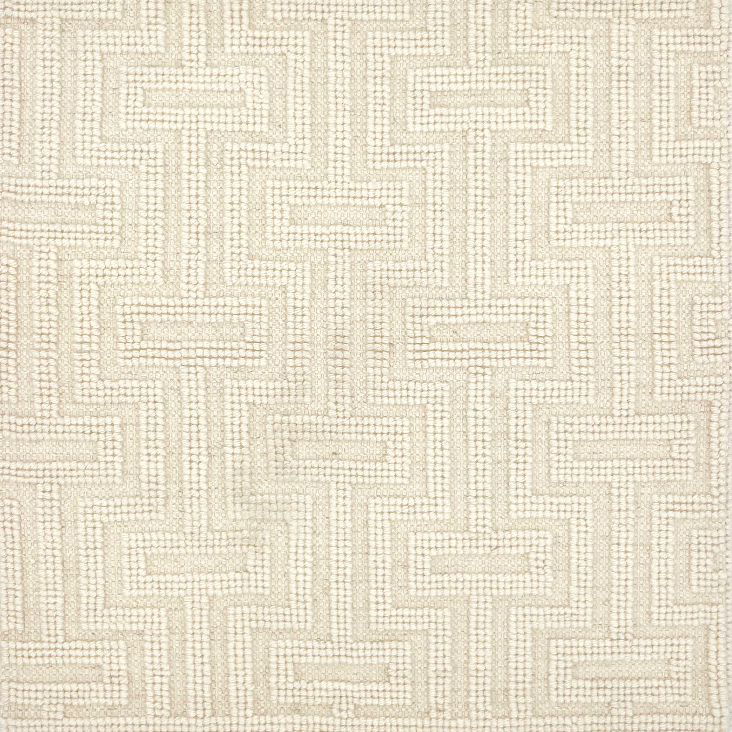 A close-up of a handwoven carpet with a repeating geometric maze in cream