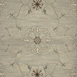 Close up of hand woven rug in a floral filigree pattern in grey, brown and cream on a grey-blue field.