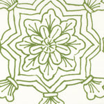 Detail of fabric in a floral medallion print in green on a white field.