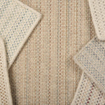 A scattered pile of broadloom carpets in a textural stripe in a range of colors.