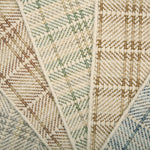 Close-up of f broadloom samples with plaid pattern in beige, brown, and blue.