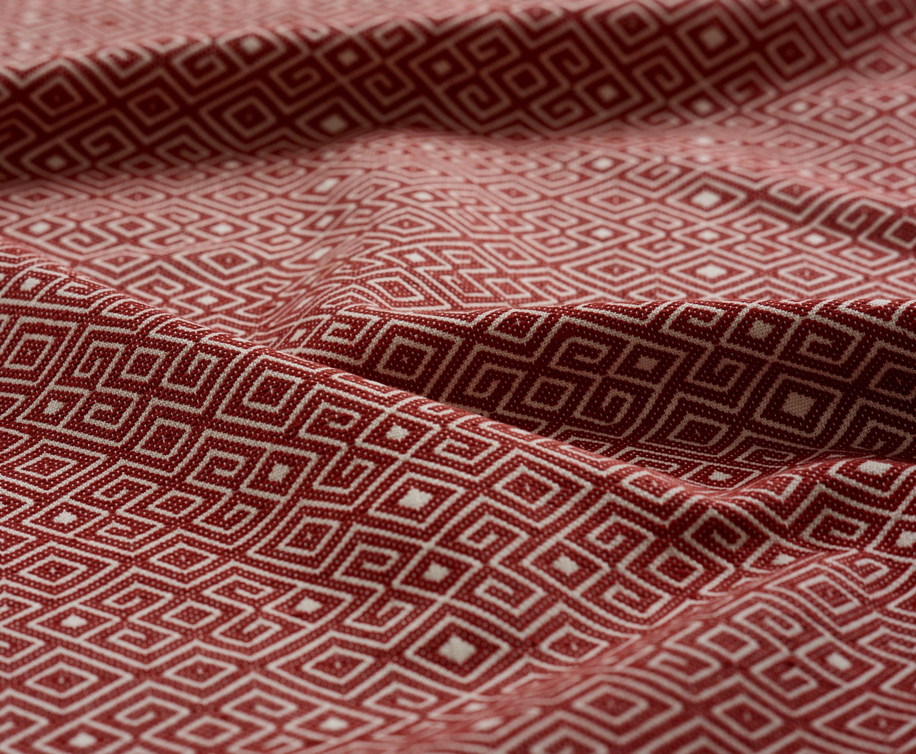Red and white geometric patterned fabric gently draped