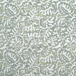 Fabric in a botanical paisley print in white on a blue-green field.