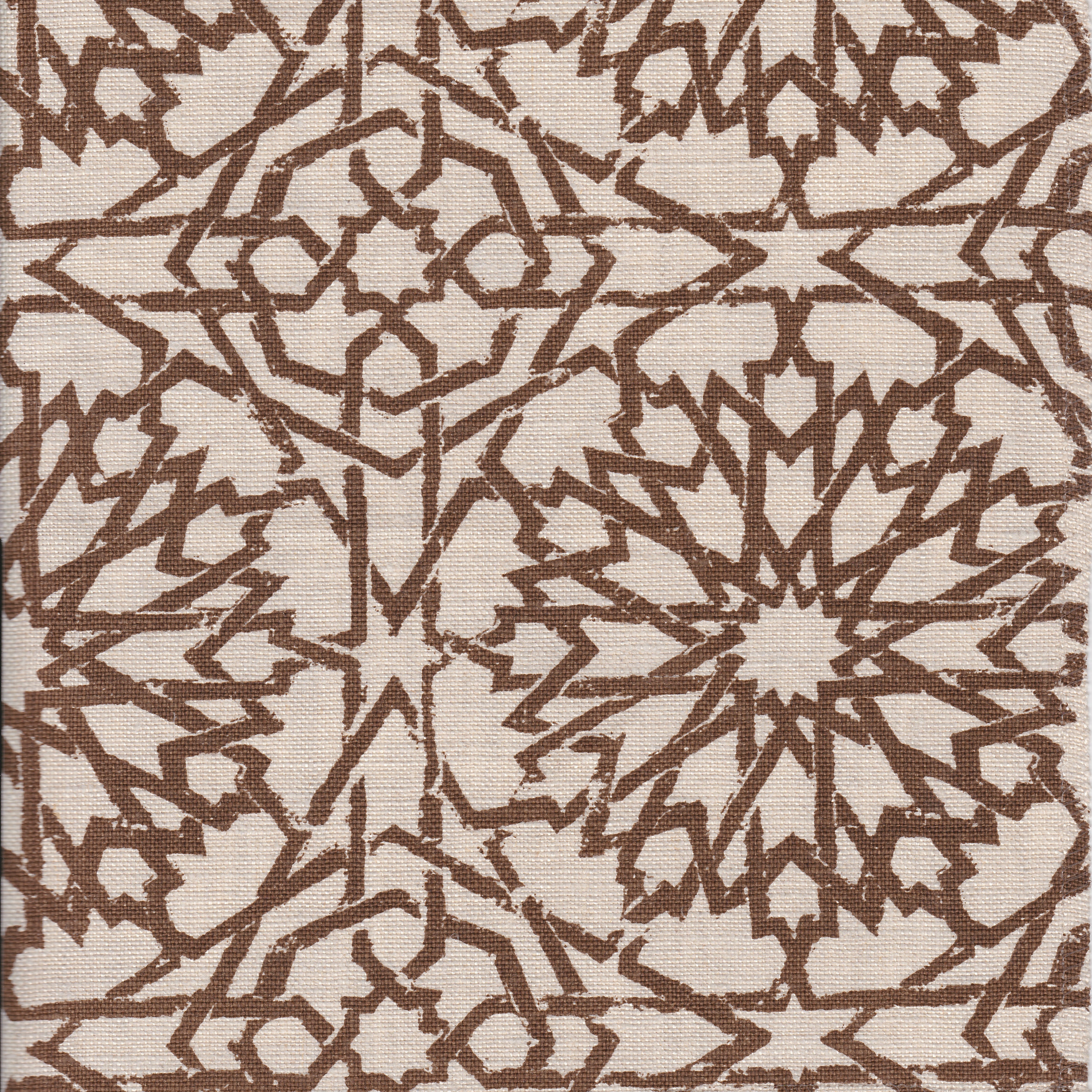 Detail of fabric in a small-scale lattice print in brown on a cream field.