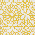 Detail of fabric in a small-scale lattice print in yellow on a white field.