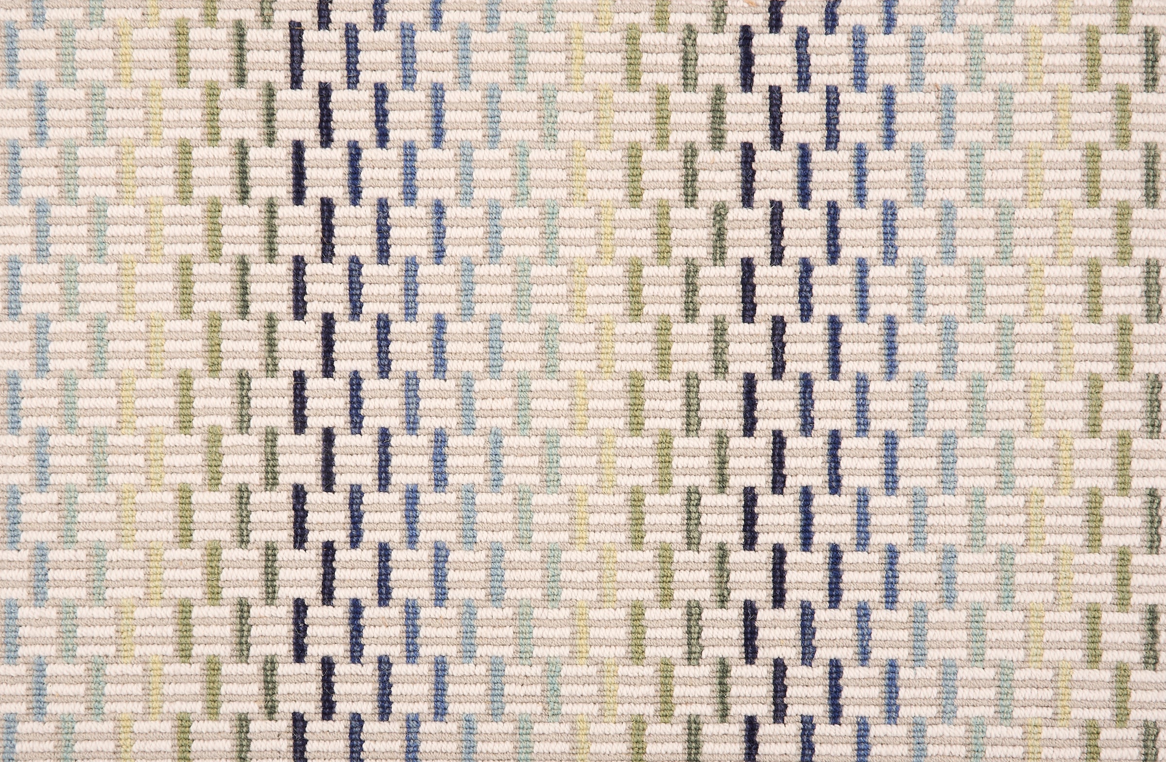 Broadloom carpet in a small ombré striped check in shades of blue and green on a cream field. 