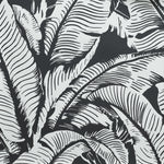 Close up of wallpaper with bold high contrast tropical banana leaf pattern in white on black. 