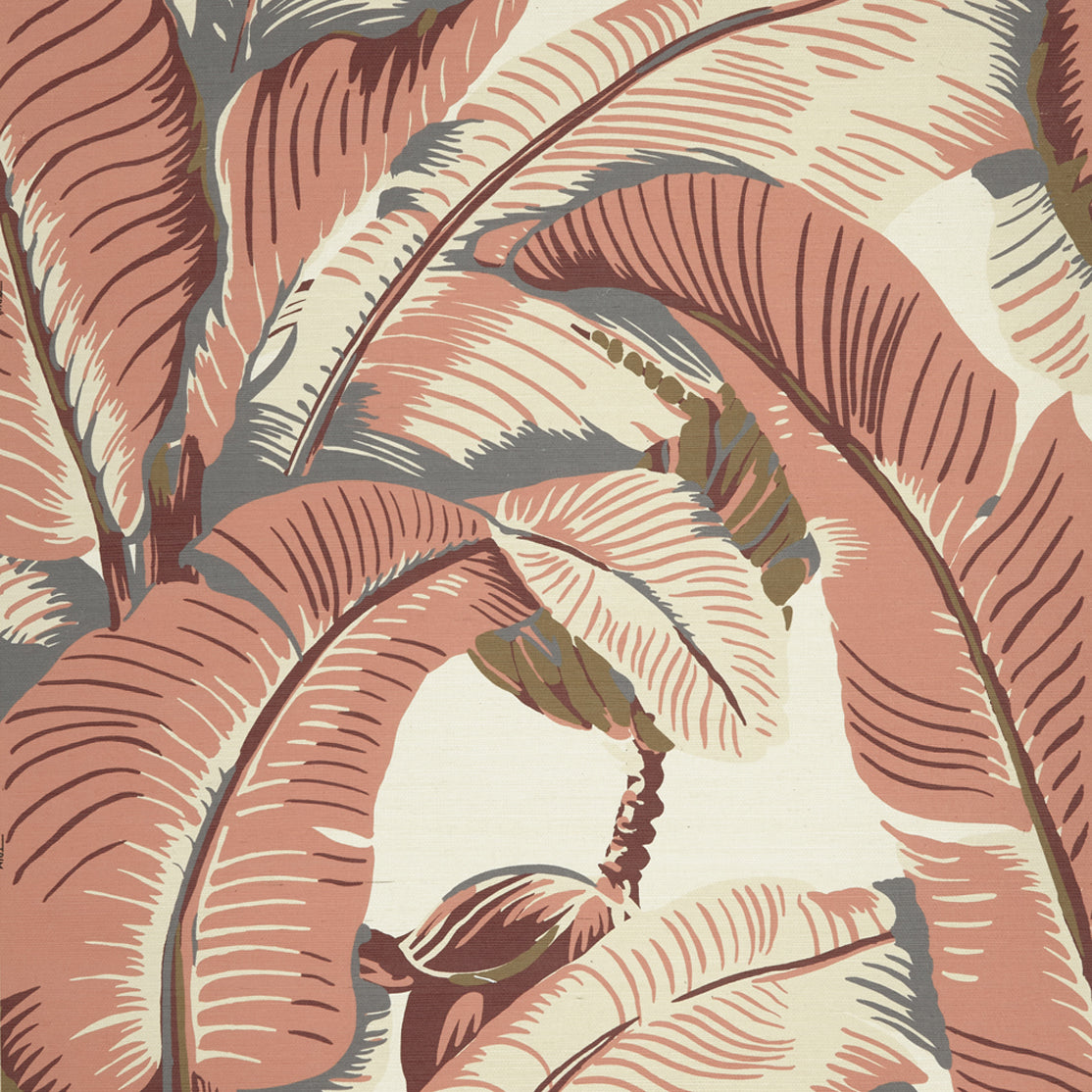 Close up of banana leaf pattern grasscloth wallpaper featuring large tropical leaves in terracotta pink, cream, and muted gray-green tones on a light cream background.