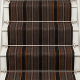 Striped flatweave runner in orange brown and black on white staircase