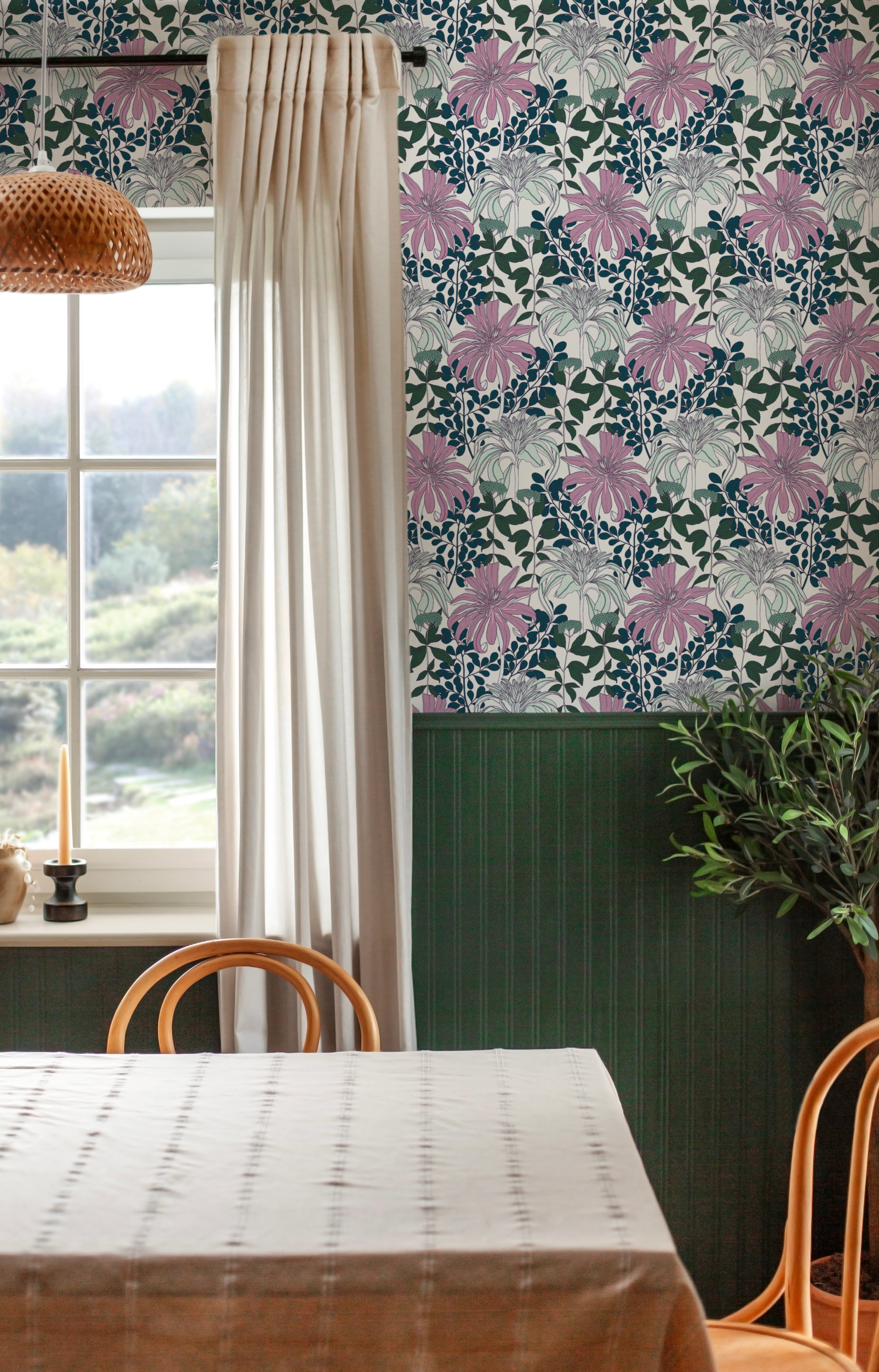 A dining room tableau with a large window and statement wall papered in a large-scale floral print.