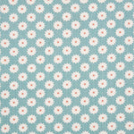 Detail of fabric in a repeating blossom print in white on a light turquoise field.