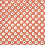 Detail of fabric in a repeating blossom print in white on a burnt orange field.
