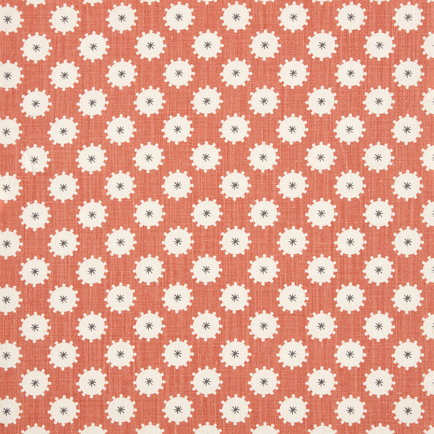 Detail of fabric in a repeating blossom print in white on a burnt orange field.