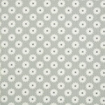 Detail of fabric in a repeating blossom print in white on a gray field.