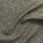 Detail of gently draped printed fabric with a white celestial dotted pattern on a muted sage green background. 