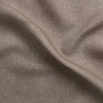 Detail of gently draped printed fabric with a white celestial dotted pattern on a warm beige background. 