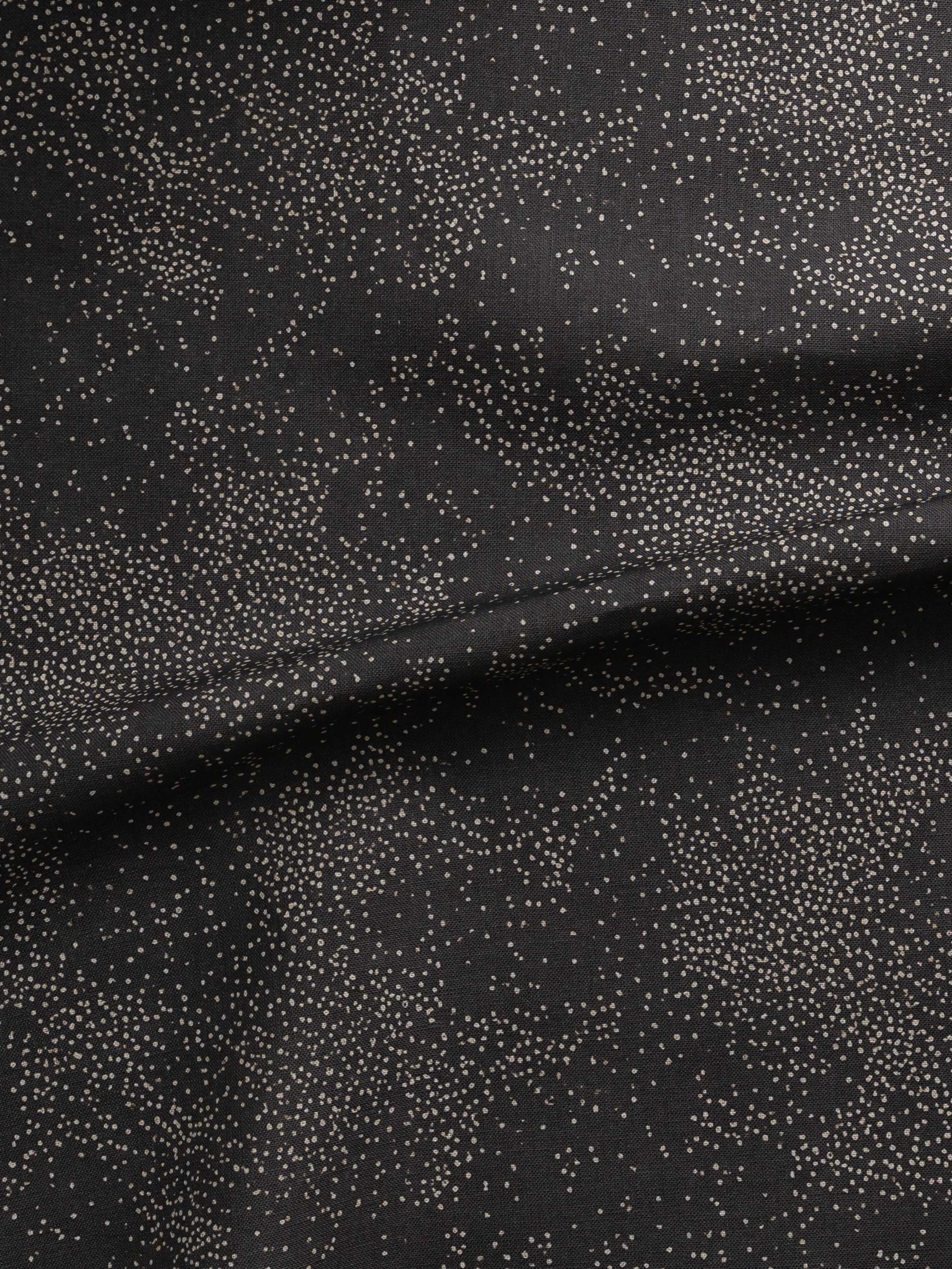 Detail of gently draped printed fabric with a white celestial dotted pattern on a muted black background. 