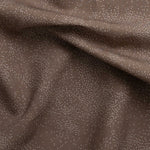 Detail of gently draped printed fabric with a white celestial dotted pattern on a warm clay background. 