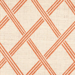Detail of fabric in a diamond lattice print in orange on a cream field.