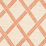 Detail of fabric in a diamond lattice print in orange on a cream field.