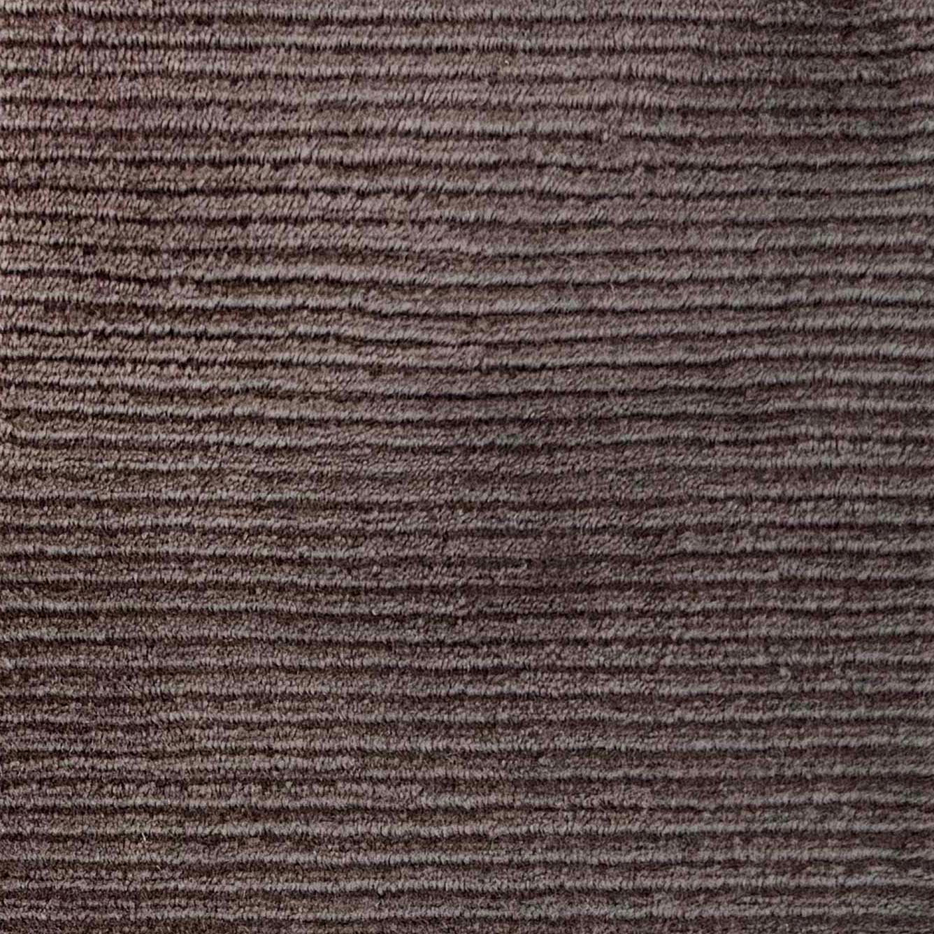 Close up of broadloom carpet with solid cut pile ribbed stripe in dark brown.
