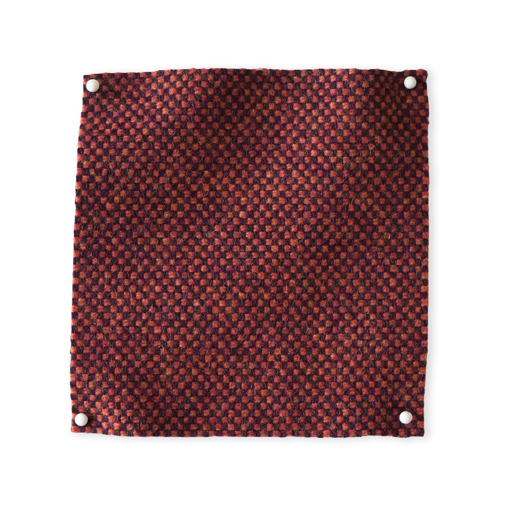 Pinned swatch of woven fabric in dark red. 