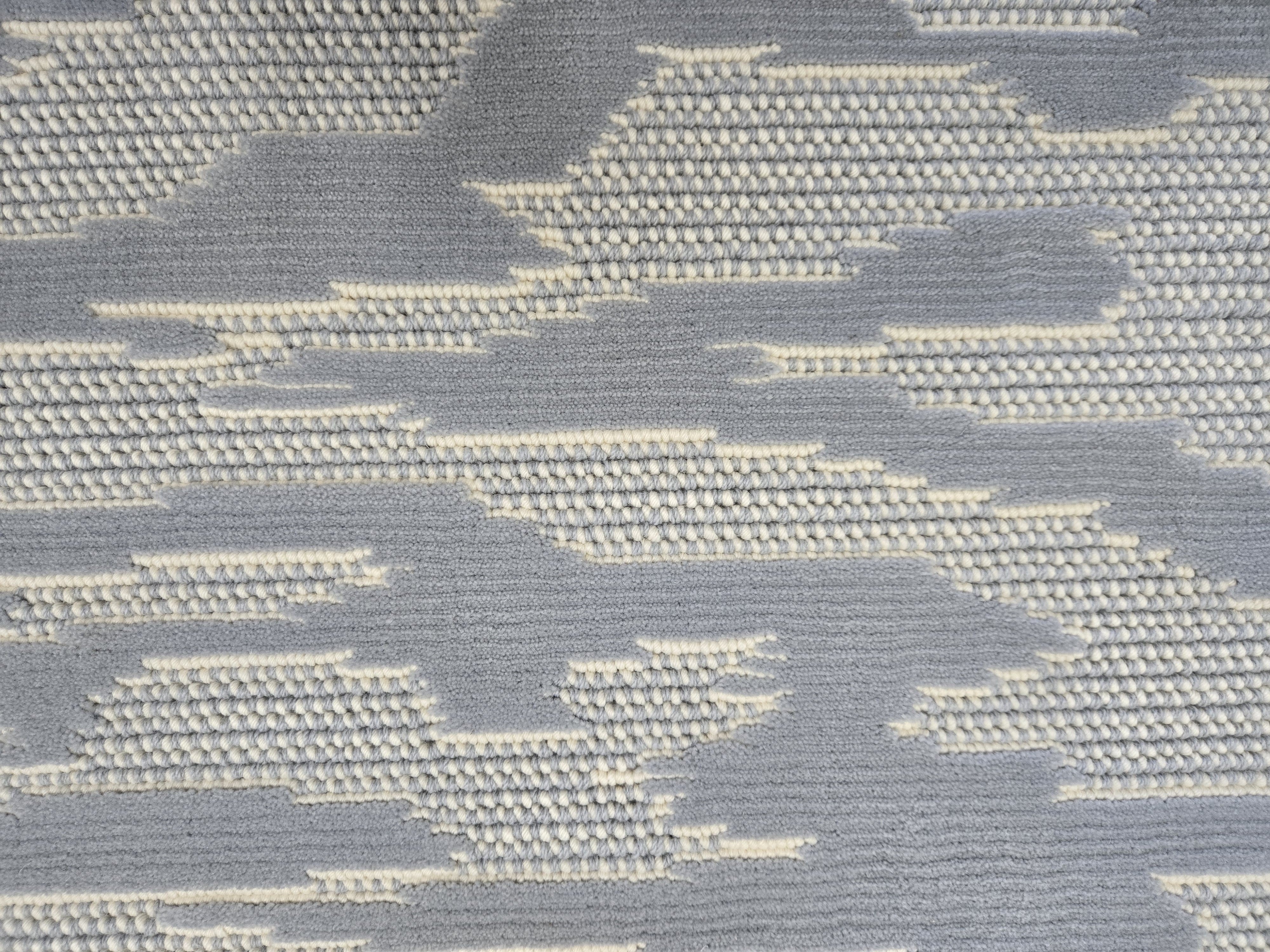 Broadloom carpet detail in an abstract cloud design in ivory and chambray blue.