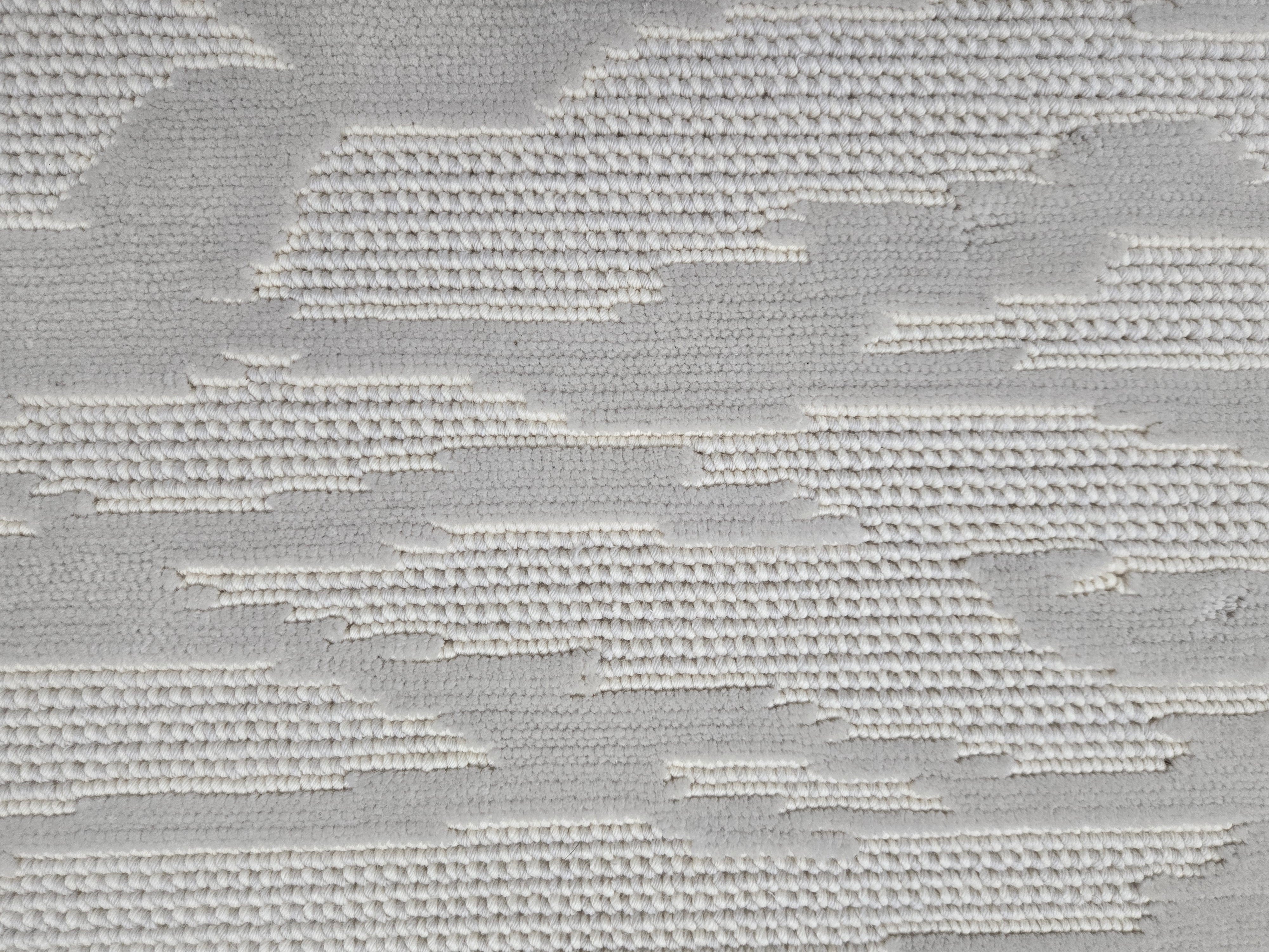 Broadloom carpet detail in an abstract cloud design in ivory and soft grey.