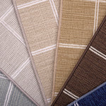 Broadloom carpet samples in plaid pattern in blue, tan, beige, brown and blue.