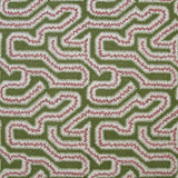 Detail of fabric in a dense meandering print in white, pink and purple on a green field.