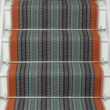 Striped flatweave runner in orange black blue on white staircase