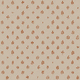 Detail of fabric in a repeating leaf print in burnt orange on a cream field.