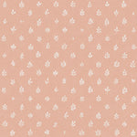 Detail of fabric in a repeating leaf print in cream on a light pink field.